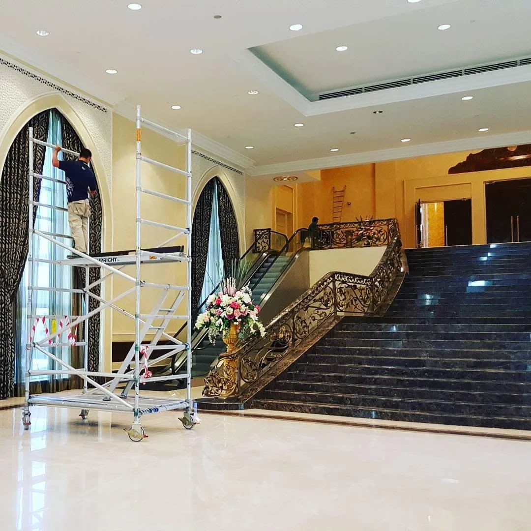 Scaffold beside arched windows and a broad staircase during textured-finish works at Istana Negara.