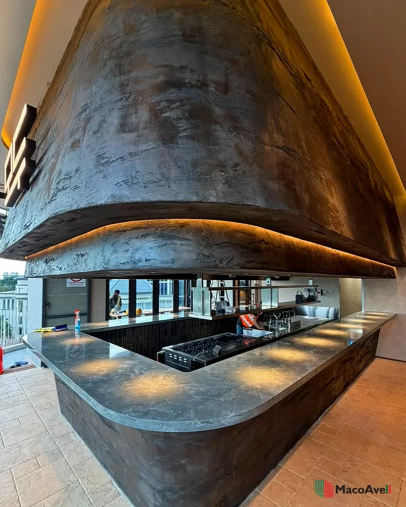 Wide view of the StoneArt project at KLCGG, showing the curved textured overhead feature and wraparound kitchen counter.