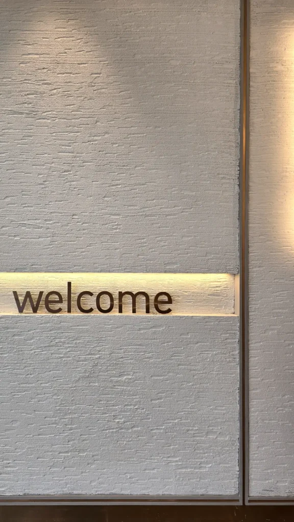 Full view of the Vellcco Custom wall with welcome lettering, recessed lighting and slim metal trim.