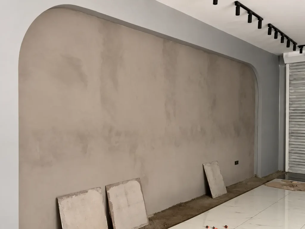 Angled view of a Vellplas MA02 feature wall with rounded corners beneath black track lights in Kuala Lumpur.
