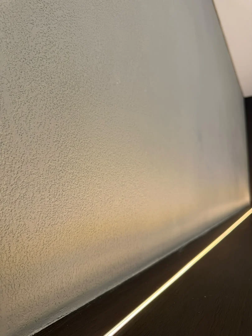 Angled view of Vellcco MA01 pitted texture above a dark ledge with warm strip lighting.